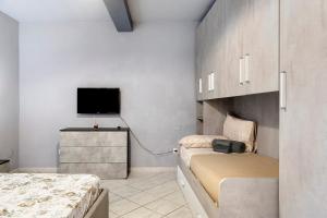 a bedroom with two beds and a flat screen tv at Dimora il Respiro di Pisa in Pisa