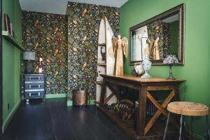 a room with green walls and a table and a surfboard at Maison Vitis in Fuissé