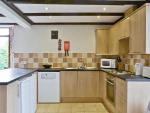 a kitchen with wooden cabinets and a white refrigerator at Bay - E4482 in Catfield