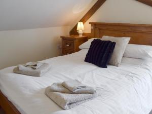 a bedroom with a white bed with towels on it at Bay - E4482 in Catfield