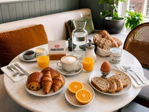 a table with a breakfast of croissants and orange juice at Frenchdoor Orléans Cloître in Orléans