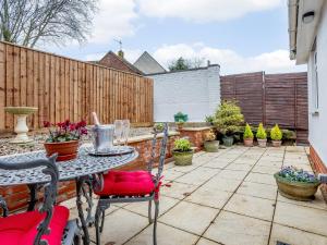 a patio with a table and chairs and a fence at Vineyard's Apartment - Uk36748 in Ely