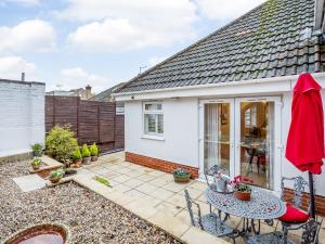 a small white house with a table and chairs at Vineyard's Apartment - Uk36748 in Ely