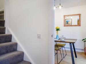 a hallway with a table and a stairway with a table and chairs at Vineyard's Apartment - Uk36748 in Ely