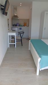 a room with a bed and a table and a kitchen at Poseidon Complex in Paleokastritsa