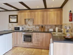 a kitchen with wooden cabinets and a microwave at Mint - E4322 in Catfield