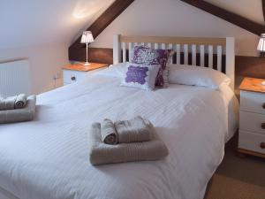 a bedroom with a large white bed with towels on it at Mint - E4322 in Catfield