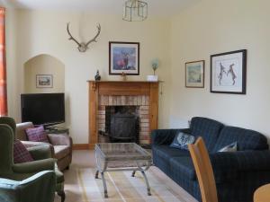 a living room with two couches and a fireplace at Cloud Cottage in Duns