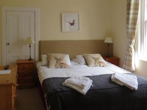 a bedroom with a bed with towels on it at Cloud Cottage in Duns +4 photos