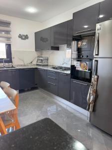 a kitchen with stainless steel appliances and a table at إقامة الرمال الذهبية in Les Hamiane