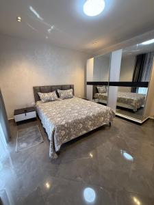 a bedroom with a large bed and a mirror at إقامة الرمال الذهبية in Les Hamiane