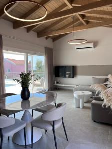 a living room with a glass table and chairs at Zefy's Scenic Oasis in Pesádha