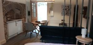 a living room with a kitchen and a table with chairs at Cas'ArtiGè in Troyes