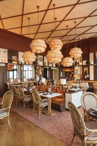 a dining room with tables and chairs and chandeliers at Hôtel Le Café de Paris in Biarritz