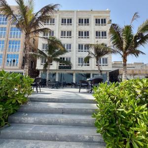 a building with palm trees and stairs in front of it at المنصور 3 in Salalah