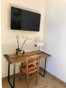 a wooden desk with a chair and a television on a wall at Château de la Mothe in Olivet