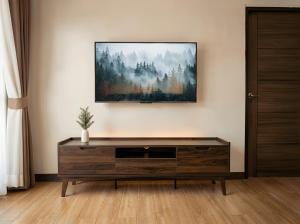 a living room with a tv on the wall at Thara Bohemia Villa in Hinkong