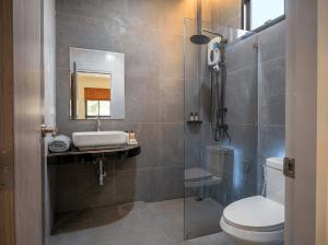 a bathroom with a toilet and a sink and a mirror at Thara Bohemia Villa in Hinkong +6 photos