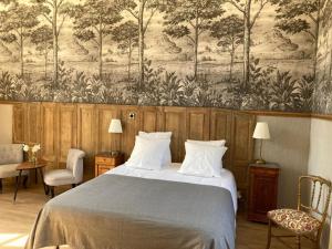 a bedroom with a large bed and a wall mural at Château de la Mothe in Olivet +33 photos