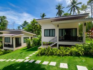 a house with a lawn in front of it at Thara Bohemia Villa in Hinkong