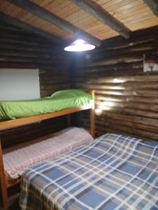 a bedroom with two bunk beds in a log cabin at Cabañas y Bungalow " La Comarca" in Concepción del Uruguay +89 photos