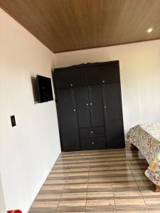 a bedroom with black cabinets and a wooden floor at Cabañas Casa Tucano in San Ramón