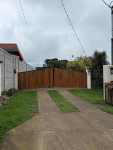 a wooden fence in front of a driveway at Cabañas Casa Tucano in San Ramón