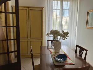 a dining room table with a vase of flowers on it at Casa FERRIGNO in Portoferraio