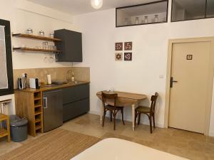 a kitchen with a wooden table and a table and chairs at Le mas de Marie in Taulignan
