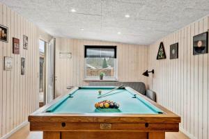a ping pong table in a room with a pool at sj278-Bjert-Binderup-Strandpark-80 in Åbjerg