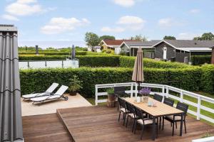 a wooden deck with a table and chairs and an umbrella at sj278-Bjert-Binderup-Strandpark-80 in Åbjerg