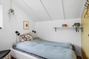 a bedroom with a bed in a room with white walls at sj278-Bjert-Binderup-Strandpark-80 in Åbjerg