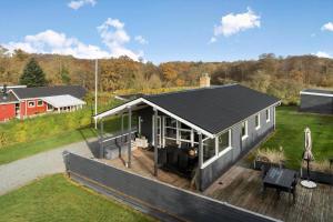 a house with a black roof on a wooden deck at SJ277-Haderslev-Kelstrup-Norreskov-36 in Haderslev +23 photos