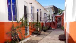 an alley with buildings and plants on the side at Hogar flores in La Ceiba
