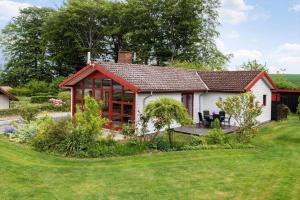 a white cottage with a red roof and a garden at SJ227-Hejls-Ae-Skovbryn-33 in Hejls