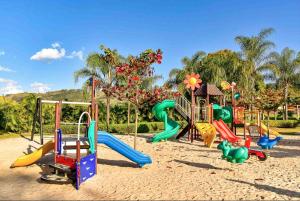 a playground with colorful playground equipment in a park at Tayayá Aqua Resort in Ribeirão Claro