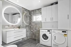 a white bathroom with a washing machine and a sink at SJ227-Hejls-Ae-Skovbryn-33 in Hejls +15 photos