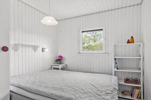 a white bedroom with a bed and a window at SJ227-Hejls-Ae-Skovbryn-33 in Hejls