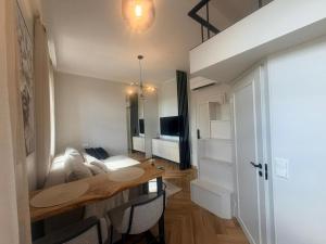a room with a table and a living room with a couch at Keskväljaku Studio apartment in Võru