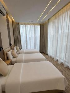 a hotel room with four beds and a large window at Al Badr Villas Resort in Sawdāʼ