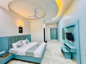a bedroom with a bed and a tv in it at Hotel JD Fortune in Anand