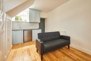 a living room with a black couch in a kitchen at Host & Stay - The Spinney in Consett