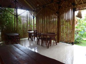a room with tables and chairs in a bamboo building at Shibui Garden Bungalows and Restaurant in Tanjung