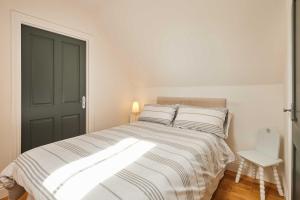 a bedroom with a bed with white sheets and a door at Host & Stay - The Spinney in Consett +7 photos