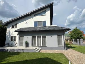 a white house with a black roof at StGeorge Retreat in Sângeorgiu de Mureș