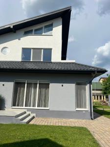 a white house with windows and a yard at StGeorge Retreat in Sângeorgiu de Mureș