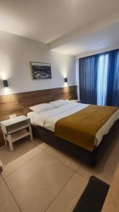 a bedroom with a large bed and a table at Tut Hotel in Antalya