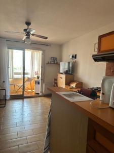 a kitchen with a counter top and a living room at Appt Cap d'Agde in Agde +6 photos