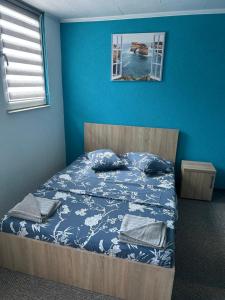 a bedroom with a bed with a blue wall at CASA DAVID in Dubova +45 photos
