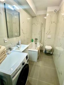 a bathroom with a sink and a tub and a toilet at David Apart in Otopeni